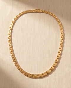 18K gold matte and high polish interlocking link collar necklace laid flat on linen, 16.5 inches