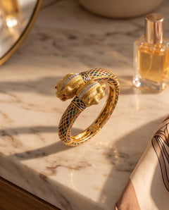 18K yellow gold double lion head cuff bracelet on marble vanity