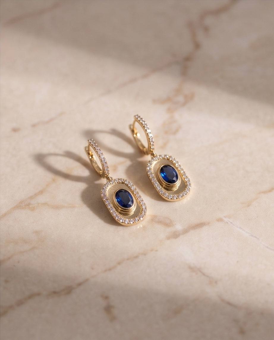 Sapphire and diamond drop earrings on marble