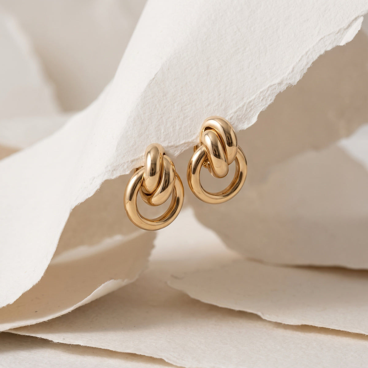 18kt Italian gold knot earrings styled with handmade paper
