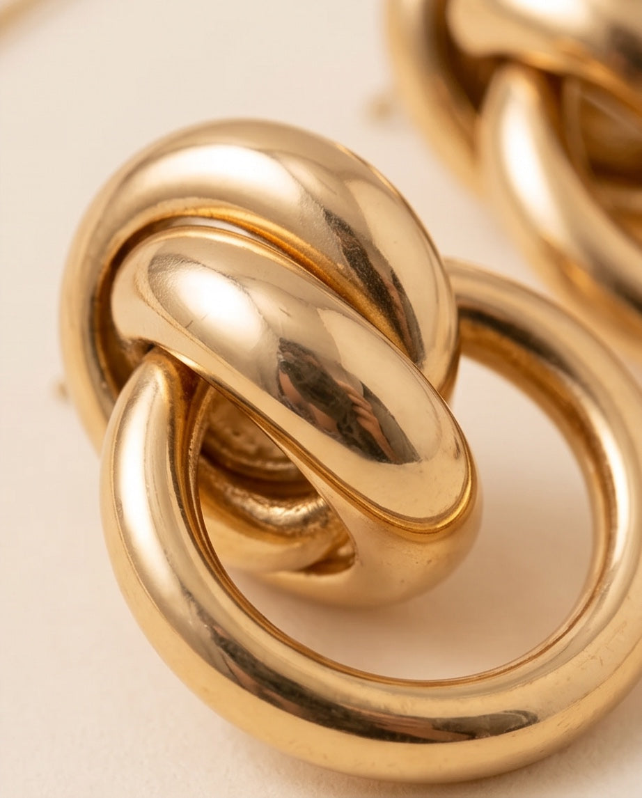 Close-up detail of high-polish 18kt gold knot and open circle
