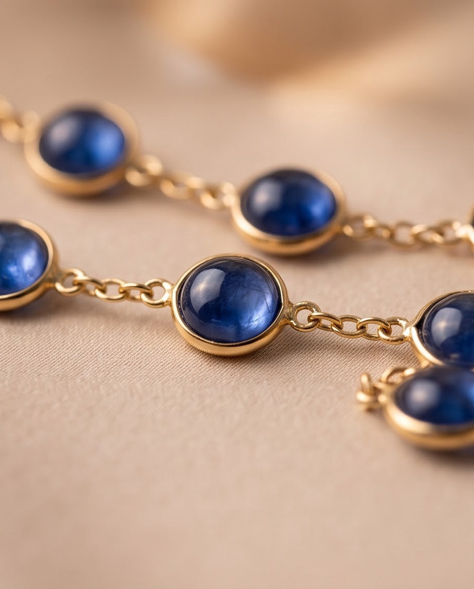 Close-up of round cabochon kyanite stones bezel-set in 14K yellow gold