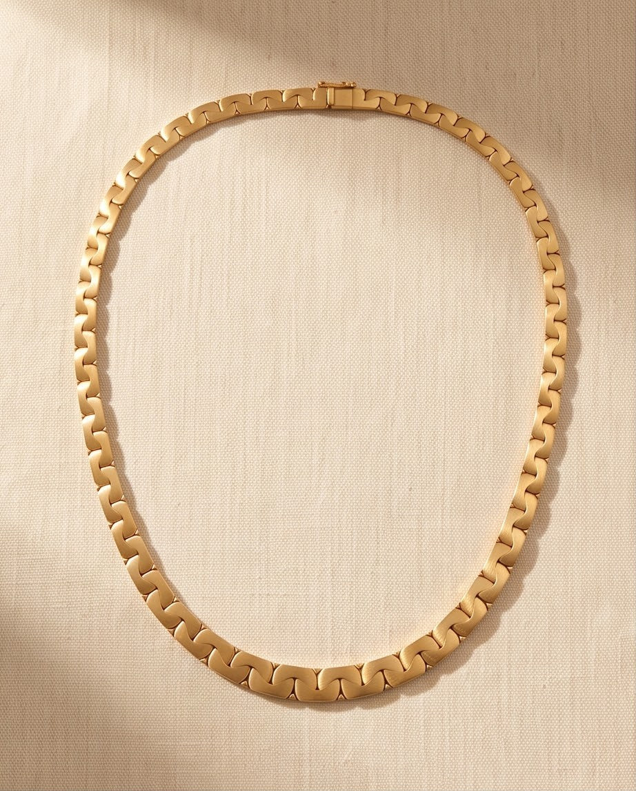 18K gold matte and high polish interlocking link collar necklace laid flat on linen, 16.5 inches