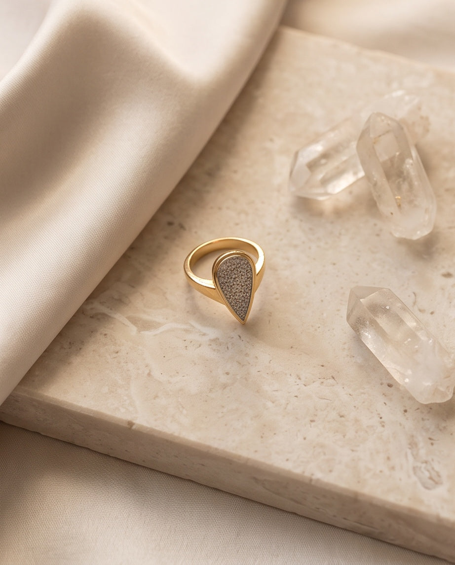 Styled view of the diamond pear plaque ring with silk and quartz