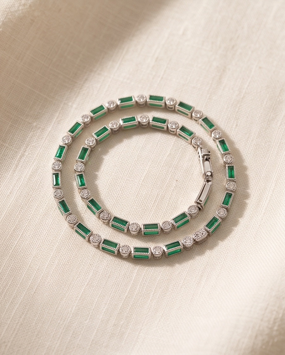 Emerald and diamond alternating line bracelet in 14K white gold, coiled on linen