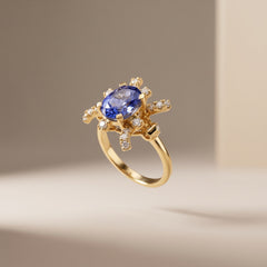 Oval tanzanite and diamond starburst ring in 18K yellow gold, angled studio view