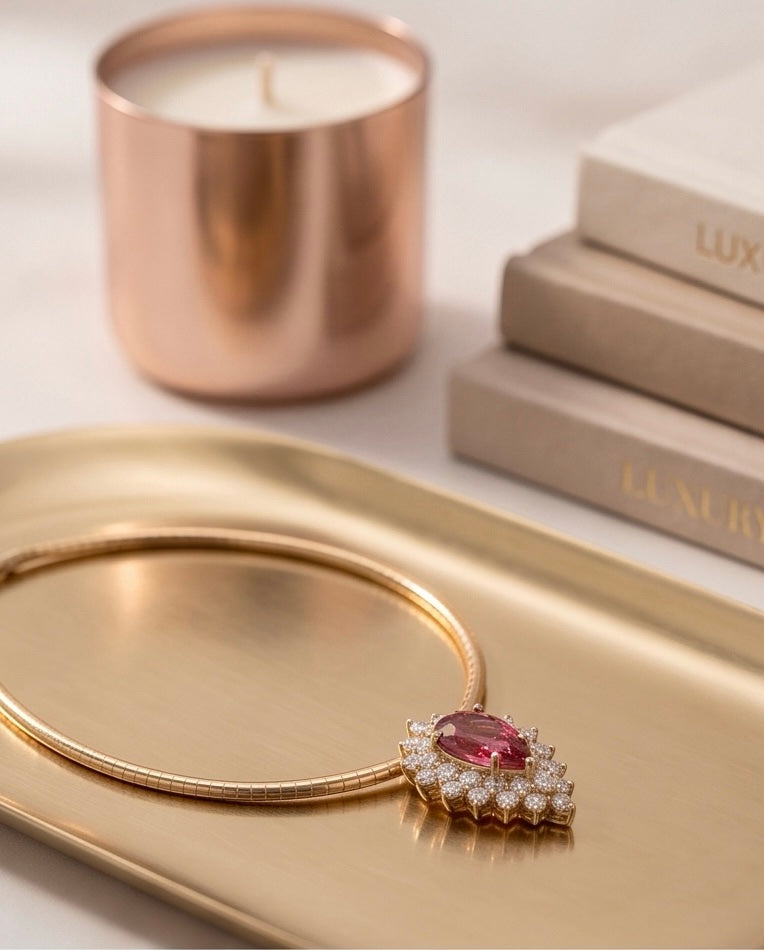 Pink tourmaline and diamond pendant on a gold tray