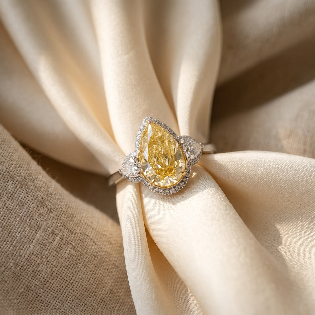 Fancy yellow pear diamond ring on cream silk