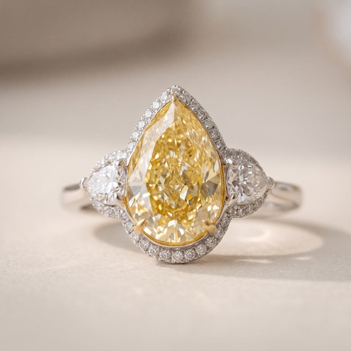 3.04 carat fancy yellow pear diamond halo ring with pear side stones, front view