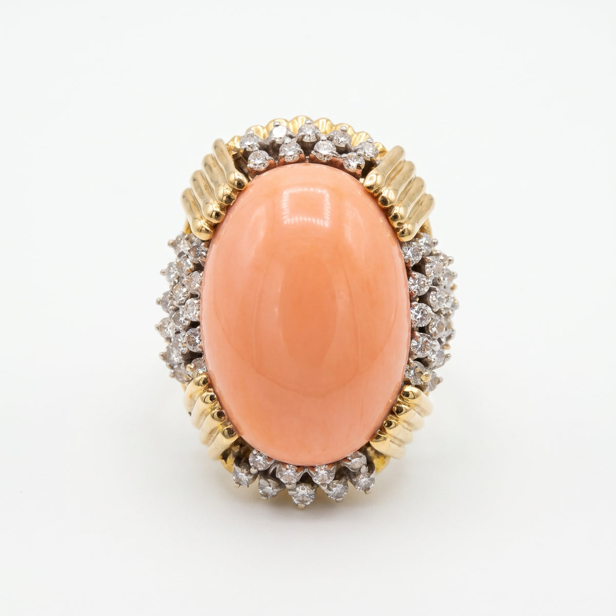 Angel skin coral diamond ring on white background showing diamond halo detail
