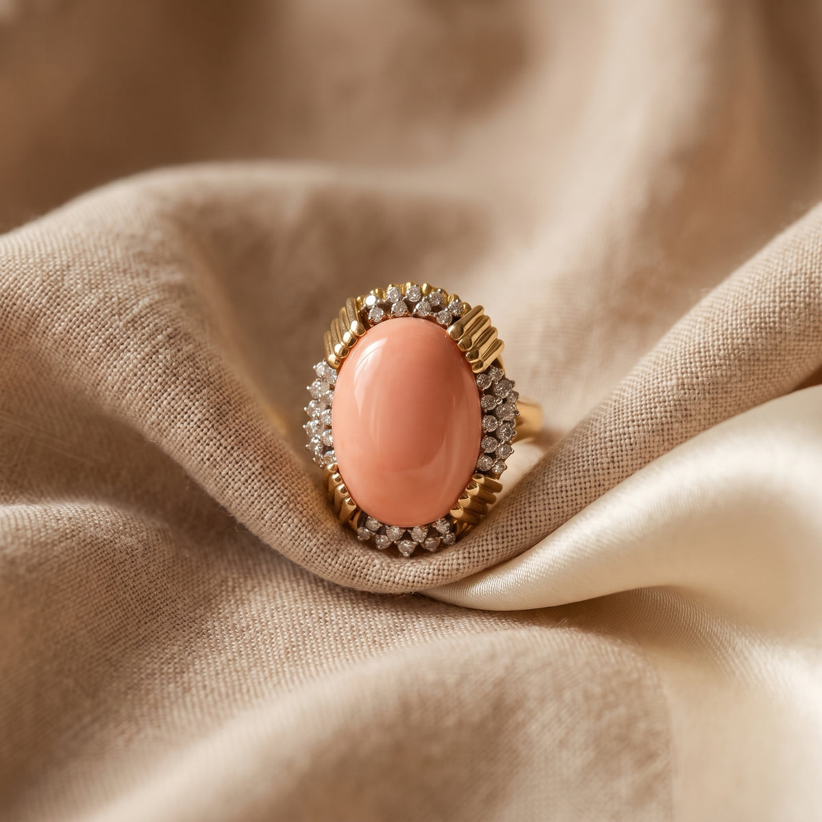 Coral and diamond ring nestled in silk fabric