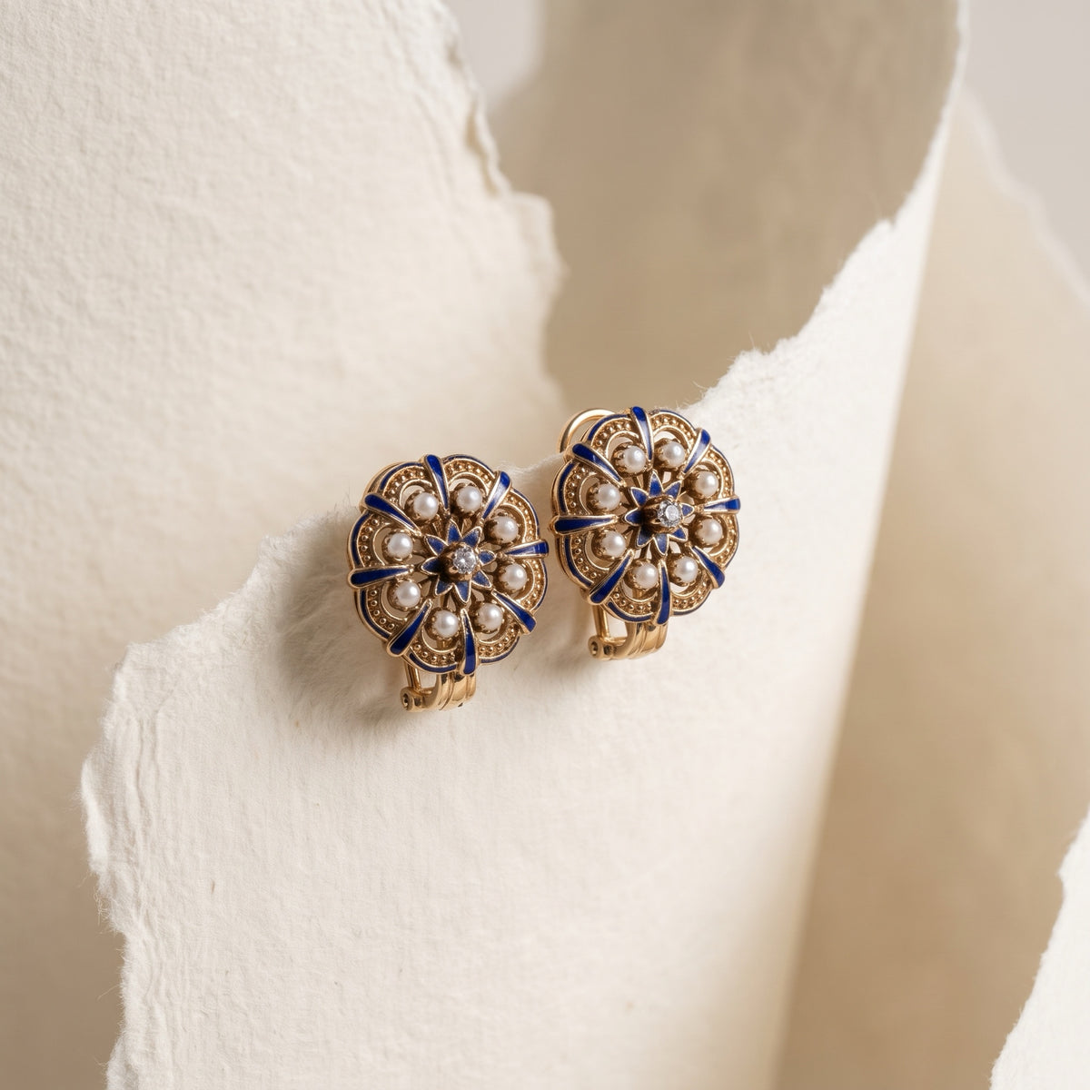 Pair of estate blue enamel seed pearl earrings showing omega backs