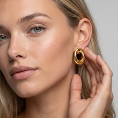 Model wearing 18kt yellow gold interlocking swirl clip-on earring