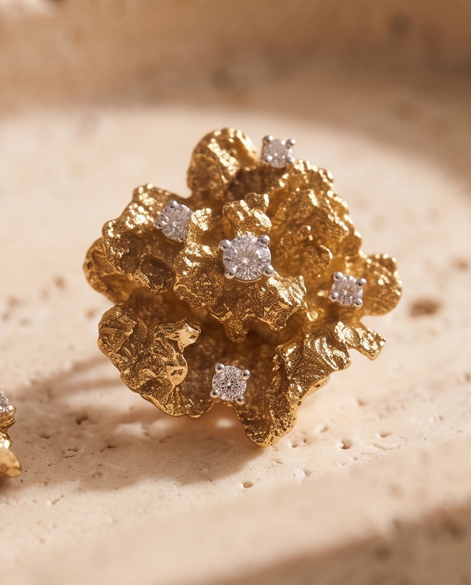 Macro detail of textured gold coral flower earring with diamonds