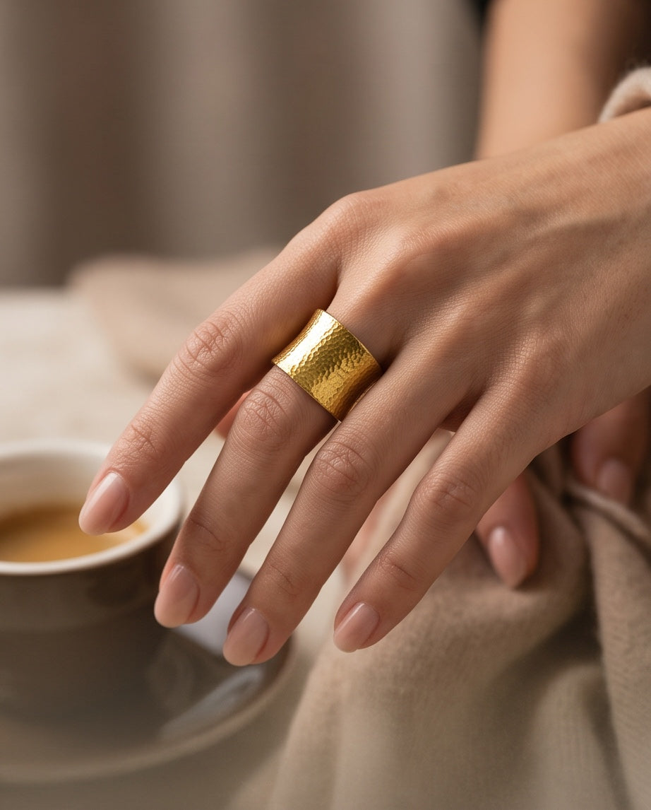 24K gold wide band ring worn on hand