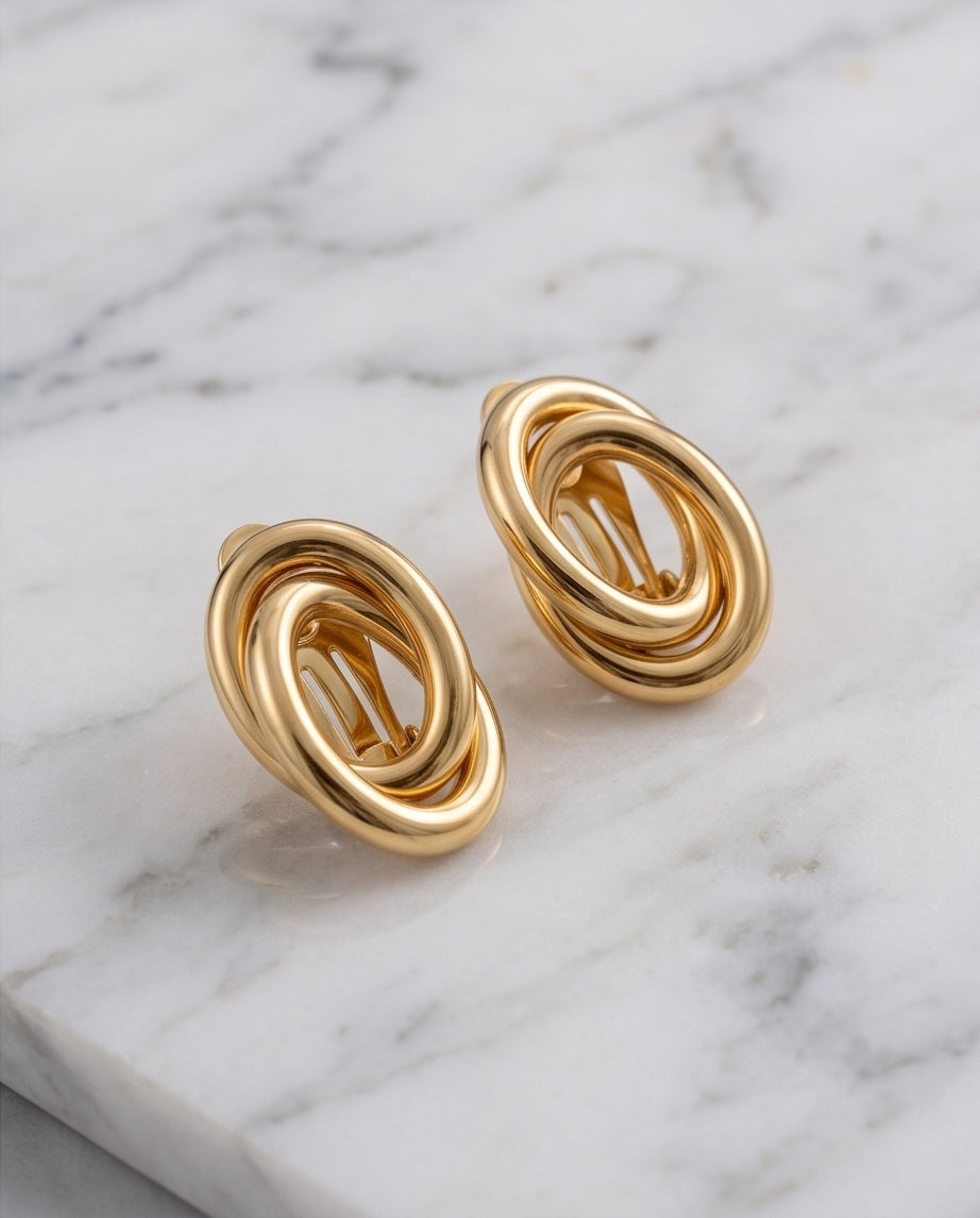 18kt yellow gold swirl earrings angled view on marble