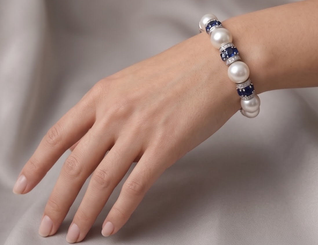 South Sea pearl and sapphire bracelet worn on the wrist against silk