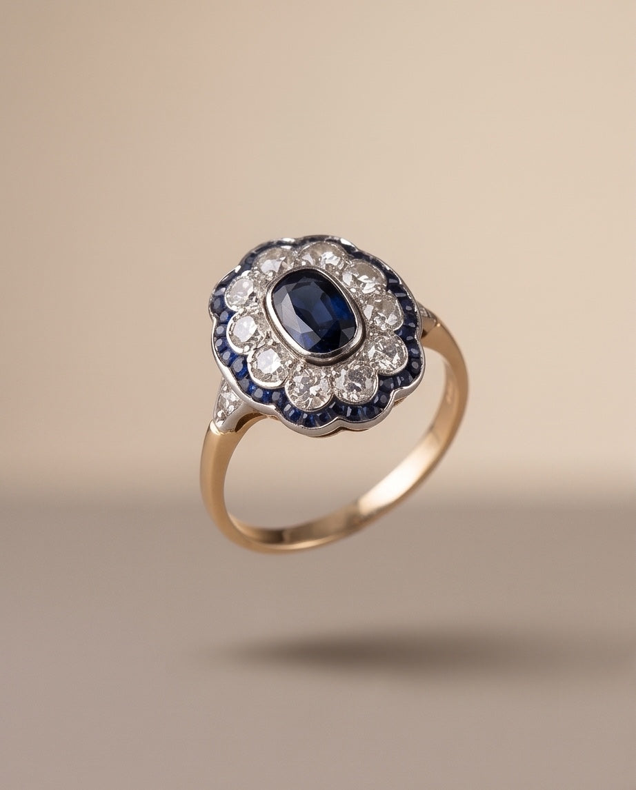 Angled view of sapphire and diamond cluster ring showing gold shank